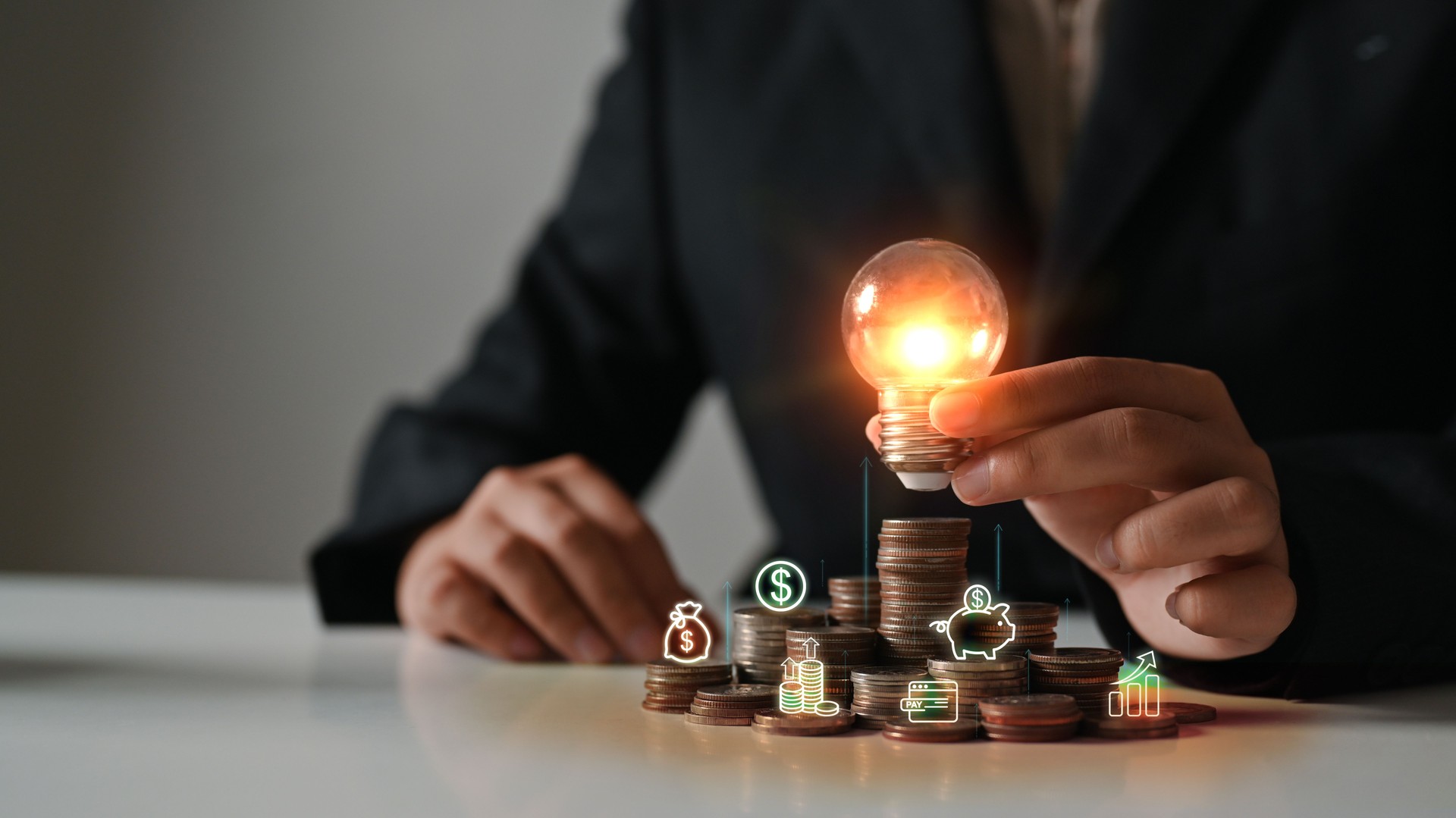 Businesswoman hand holding glowing light bulb on coin stacking. Saving money and financial growth concept