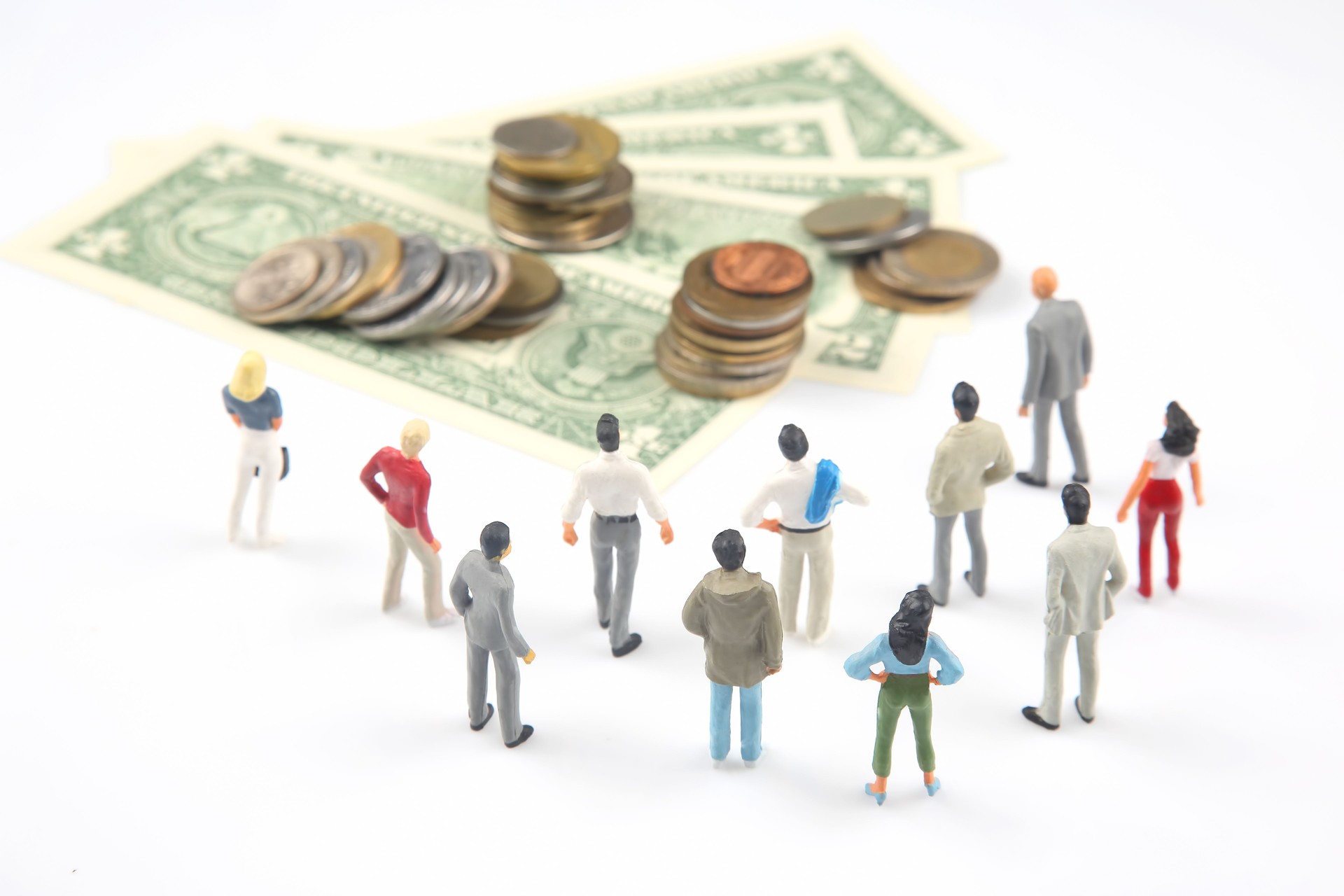 miniature people. different people are standing near dollar money. investments and earnings for work